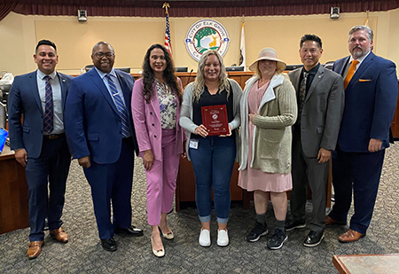 "Photo of Ciera Dulgar accepting the Above and Beyond Award from Disability Advisory Committee members and City Council"